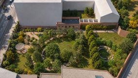 Vista area del giardino inclusivo con aree verdi, alberi e percorsi pedonali